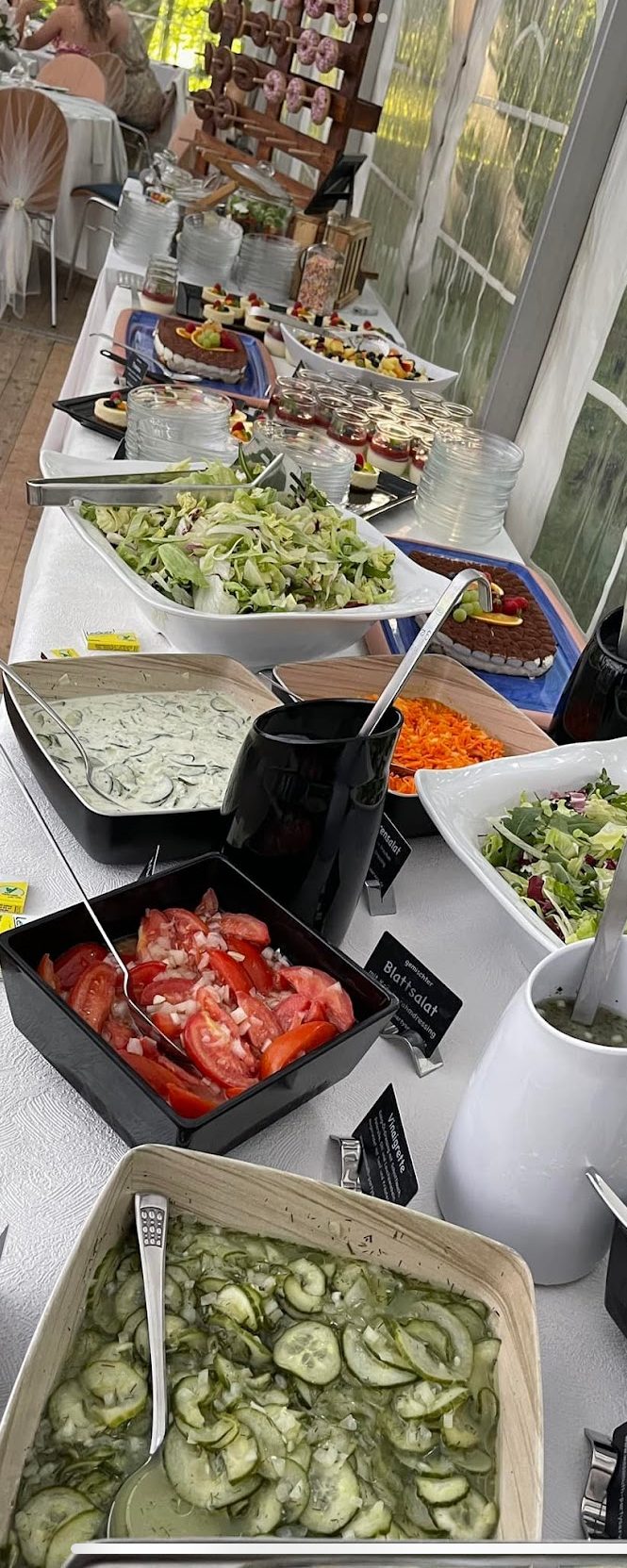 Buffet mit verschiedenen Salaten, Gemüse und Dips in Schalen angerichtet.