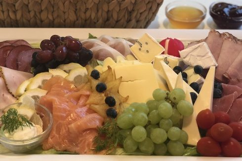 Festlich dekorierter Raum mit Buffets und platzierten Speisen auf langen Tischen.