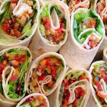 Bunte Tortilla-Wraps gefüllt mit Gemüse und Salat.
