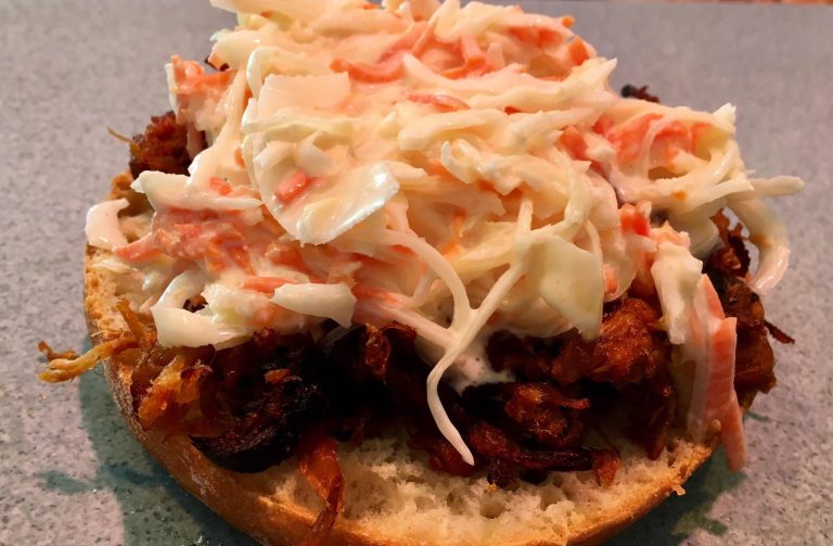 Ein Sandwich mit Pulled Pork, Krautsalat und einem weichen Brötchen.