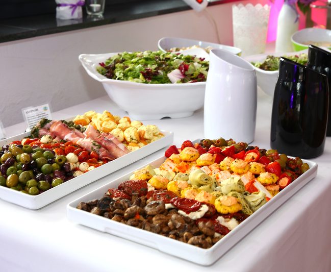 Ein Buffet mit verschiedenen Antipasti, Oliven, Käse und Salat.