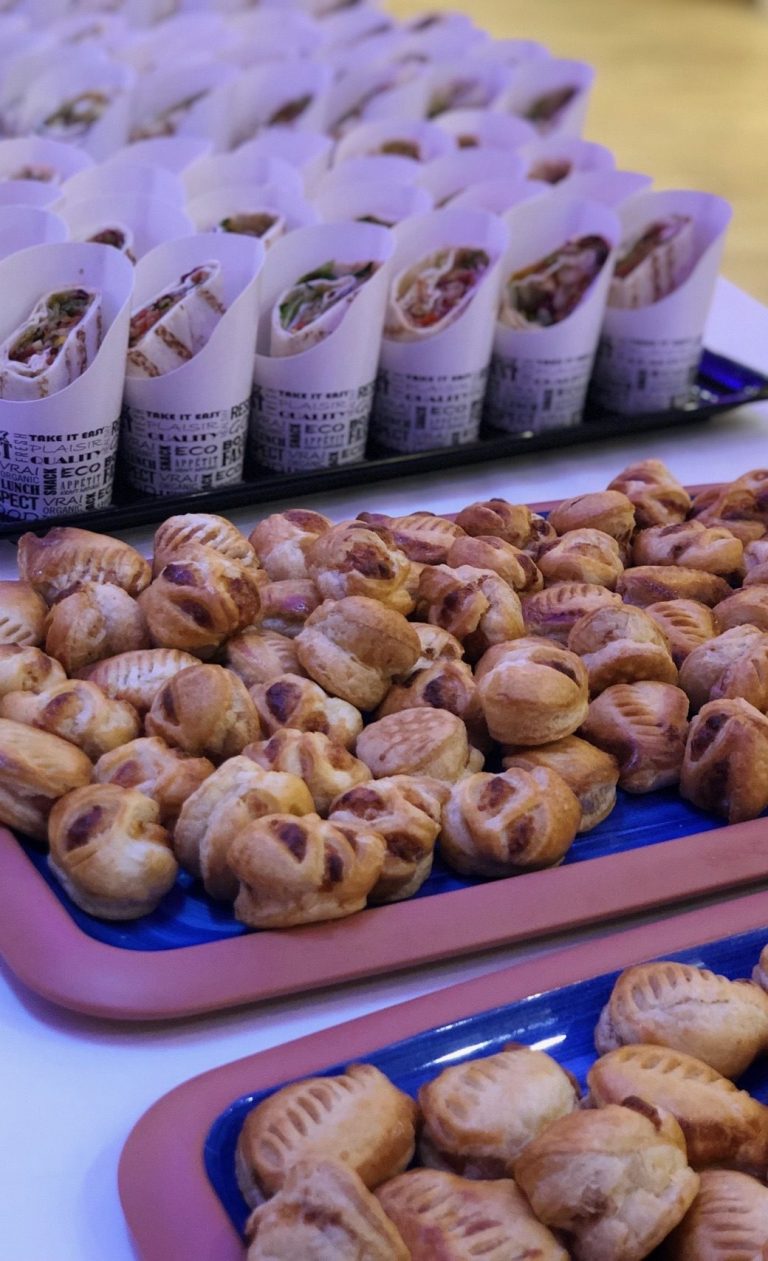 Schalen mit gefüllten Wraps und verschiedenen kleinen Gebäckstücken.