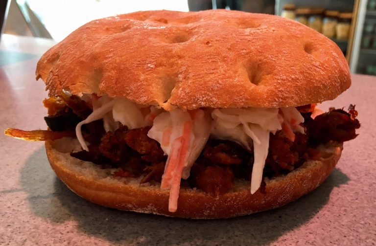 Ein Sandwich mit Pulled Pork, Krautsalat und einem weichen Brötchen.