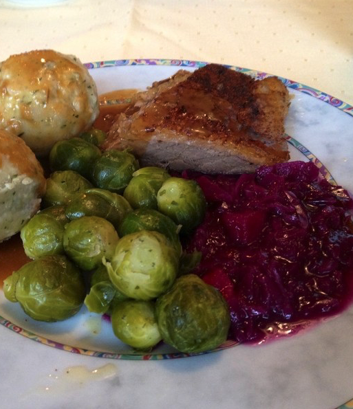 Ein Teller mit gebratener Gans, Rosenkohl und roter Bete.