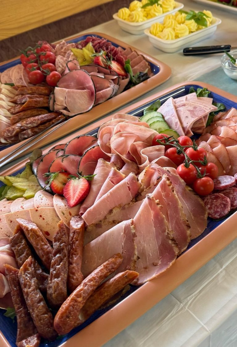 Ein Buffet mit verschiedenen Fleischsorten, salzigen Snacks und frischen Früchten.