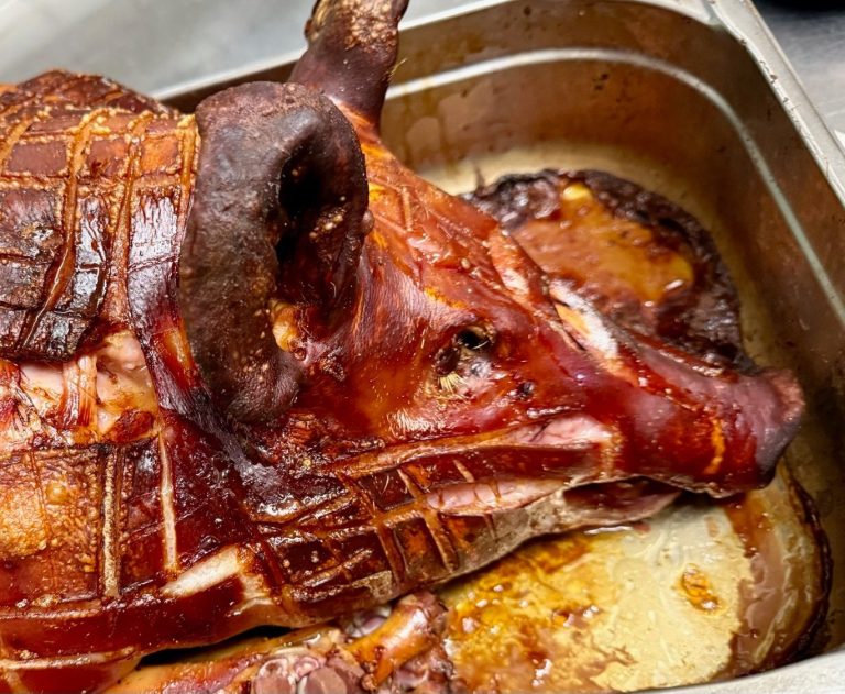 Gebratenes Schwein mit knuspriger Haut, auf einem Blech serviert.